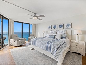 The Primary Bedroom is an oasis unto itself, offering a king bed with luxe, beachy linens and two super-comfy recliners, perfect for enjoying the spectacular gulf view from a full wall of huge windows.