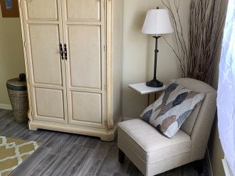 Second bedroom showing armoire and slipper chair with reading light