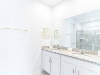The bathroom in bedroom 1 is clean and spacious with great lighting.