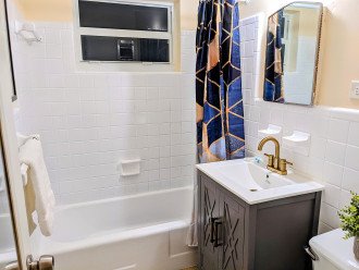 In the bathroom, you'll find Pinzon Blended Egyptian White Cotton Towels. Updated bathroom color design with modern vanity to match art deco theme throughout.