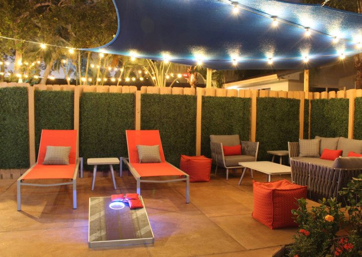 Lounge or picnic in your own patio surrounded by a warm wood fence, wrapped in artificial boxwood greens for complete privacy. The Corn Hole game illuminates at night!