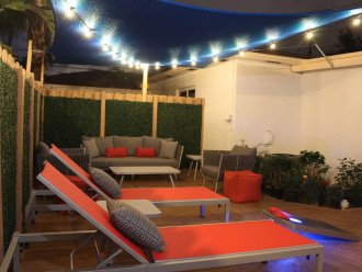 The private patio is located just outside the back door leading out from the kitchen area and can seat up to 8 people. A blue canopy above provides shade during sunny days and the string lights add ambiance to your summer evenings.