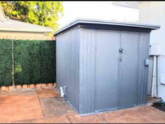 The industrial gray shed in the back patio houses a private washer and dryer inside.
