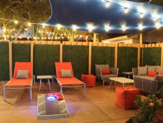 Lounge or picnic in your own patio surrounded by a warm wood fence, wrapped in artificial boxwood greens for complete privacy. The Corn Hole game illuminates at night!