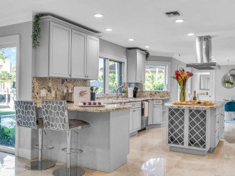 The kitchen holds all your finest amenities with high end appliances, a nice center island and comfortable bar top. The floor to ceiling windows and doors create tropical views from every angle.