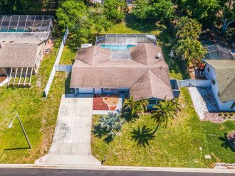 Aerial front view of our beautiful house showcasing our spacious driveway and parking. The property is surrounded by trees and is fully fenced. If you are interested in this property, send us an inquiry now!