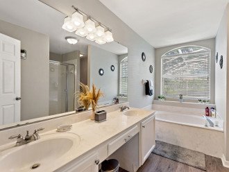 Master Queen bathroom completer with a large vanity. tub, and a walk-in shower