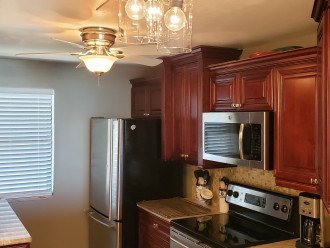 Designer kitchen w/ high end cabinets, SS appliances & granite counter tops.