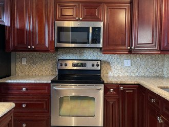 Beautiful custom kitchen with ss appliances, granite, and glass backsplash.