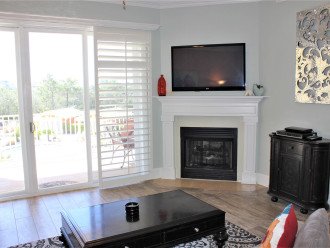 Living area with wall mount TV and pool view