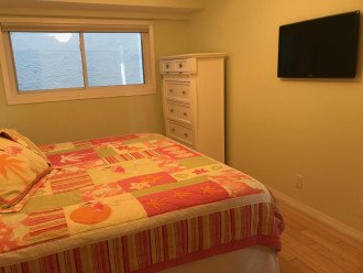 Bedroom with beachy vibe, bamboo floor, tvs in both bedrooms