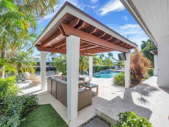 The covered outdoor cabana has a fan, smart tv, and a large sectional that is perfect for relaxing by outside with your loved ones while making memories that will last a lifetime!