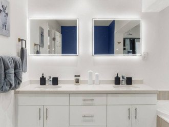 This dual sink vanity offers plenty of space to store all of your bathroom essentials, while also offering hand soap and candles to elevate the ambiance.