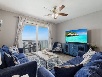Living Room offers a sofa & love seat & side chair, tv & entrance to the large balcony.