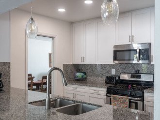 Gorgeous modern kitchen features state-of-the-art appliances. The open breakfastbar/kitchen area is a design element that brings family and friends together to sharequality time, conversation, and meal preparation.