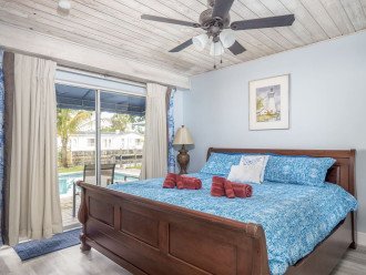 Junior Suite (Bedroom #2) with gorgeous view of the Bahama Canal! King-size sleigh bed,direct pool & backyard access, ceiling fan, dresser and closet, 45” smart TV with freeNetflix. Wide doorway.