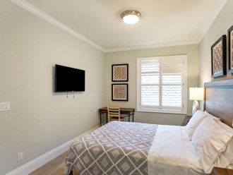 Third bedroom with queen bed, tv, and writing desk