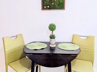 Eat-in kitchen with a leaf dining table for two that can open up for additional dining space. Above the table is a mini-vertical garden of real preserved moss and 9 vibrant, colorful preserved flowers. A true work for art. :-)
