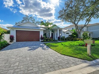 Vibrant and lush Old Florida landscaping surrounds the house exterior and welcomes you