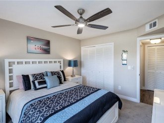 guest bedroom with queen bed, ceiling fan and TV