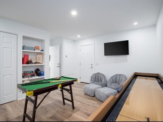 Game room, complete with tv, game tables, board games and shuffleboard.