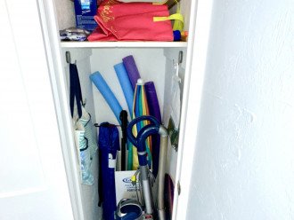 LR corner closet with umbrellas, beach bags, noodles, vacuum.
