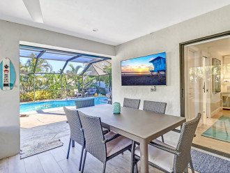 Spacious covered and screened lanai with dining seating for 6, and a smart TV.