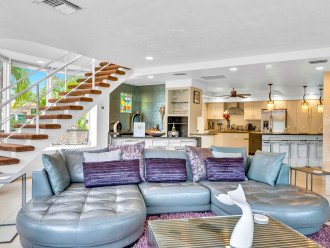 The spacious living room features outstanding views of the heated pool and waterway, a bar and a fire place.