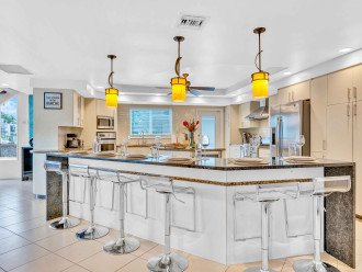 The large, eat in kitchen includes seating for eight, a professional gas stove and an oversized island.