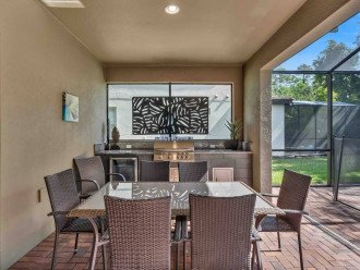 Patio with grill, mini fridge, and table with chairs