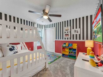 Mickey Mouse room with bunk bed (twin on top and in trundle below, full on bottom). Room includes toys for kids.