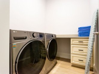 Laundry room with new front load washer and dryer and folding counter.