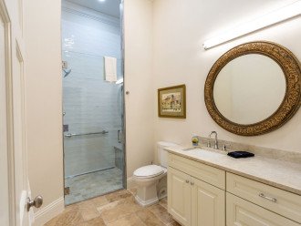 Spacious high-end bathroom with large vanity, walk in shower with shower bench.