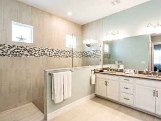 Master bathroom with custom tiled walk-in shower with a quartz double sink vanity