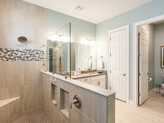 Master bathroom with custom tiled walk-in shower with a quartz double sink vanity
