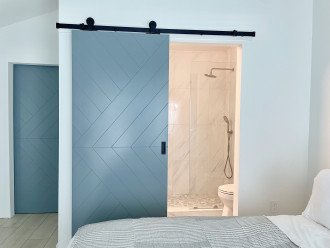 Bathrooms feature beach pebble tile walk-in showers with rain shower heads