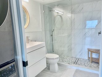 Bathrooms feature beach pebble tile walk-in showers with rain shower heads
