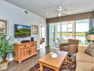 Living Room with Flat Screen TV, Fan, and Entrance to Lanai Area with Lake and Golf Views; Couch is a Pull Out!