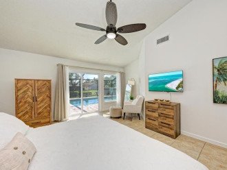 The primary bedroom has a dresser and armoire for clothing storage, direct access to the pool, and a Roku TV