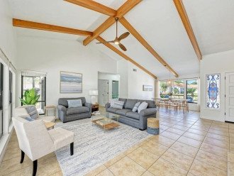 The living room is bright and spacious, with vaulted ceilings and wood beams