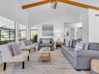 The living room is light and bright with vaulted ceilings and comfortable seating. There is a pullout couch.