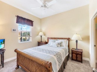 guest bedroom with queen size bed and tv