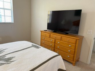 Master bedroom smart television and dresser with plenty of storage