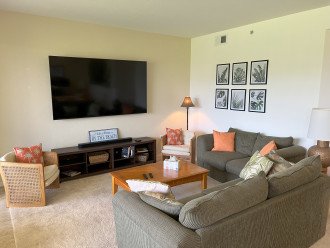 Large open family room with new 85" smart TV with soundbar looking out to golf