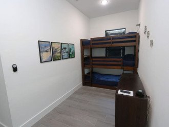 2nd Triple Bunk bedroom with 40" backlit TV, mini Nintendo game console, 3 chairs for relaxing/gaming that also convert into a sleeping mat if needed, attached bathroom and individual charging outlets with shelves for each bunk!