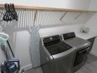 Laundry room, equipped with iron, ironing board. steamer, vacuum, mop, broom, and hangers