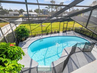 Screened lanai with heated saltwater pool, canal views, upper screened balcony.