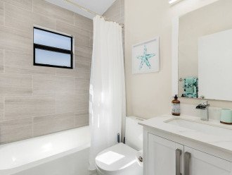 This bathroom has a tub with shower overhead.