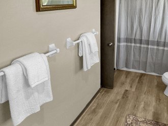 Experience ultimate relaxation with fresh and clean bath towels, perfect for enjoying a soothing soak in the tub.
