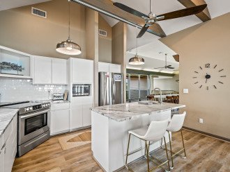 Enjoy dining in this open-concept kitchen featuring granite countertops, an abundance of natural light, and a sleek, modern design.